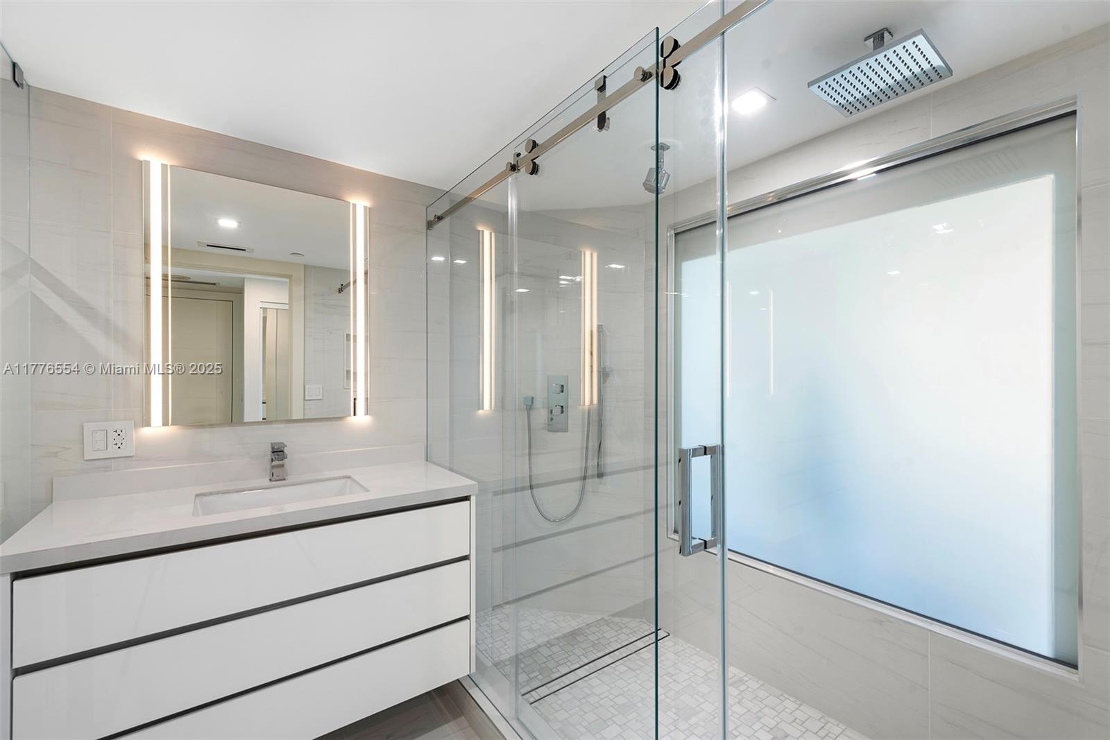 4775 Collins Avenue, Unit 2607 Miami Beach, FL 33140 - Photo 16 of 48 a bathroom with a shower sink and mirror