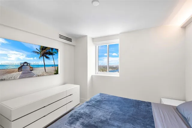a view of a bedroom with cabinet and mirror