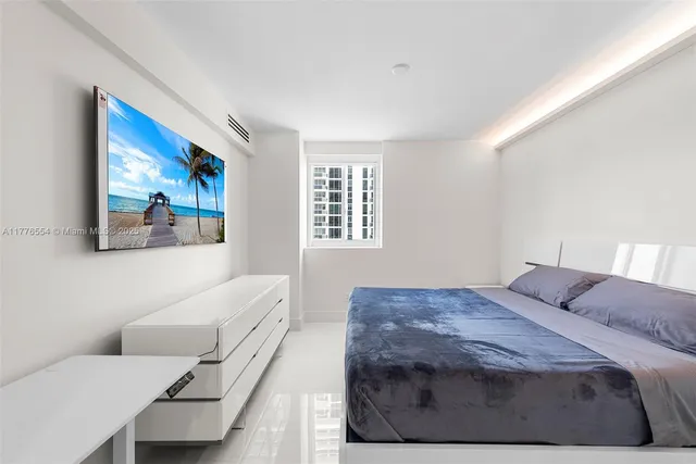 a bedroom with a bed and a painting on the wall