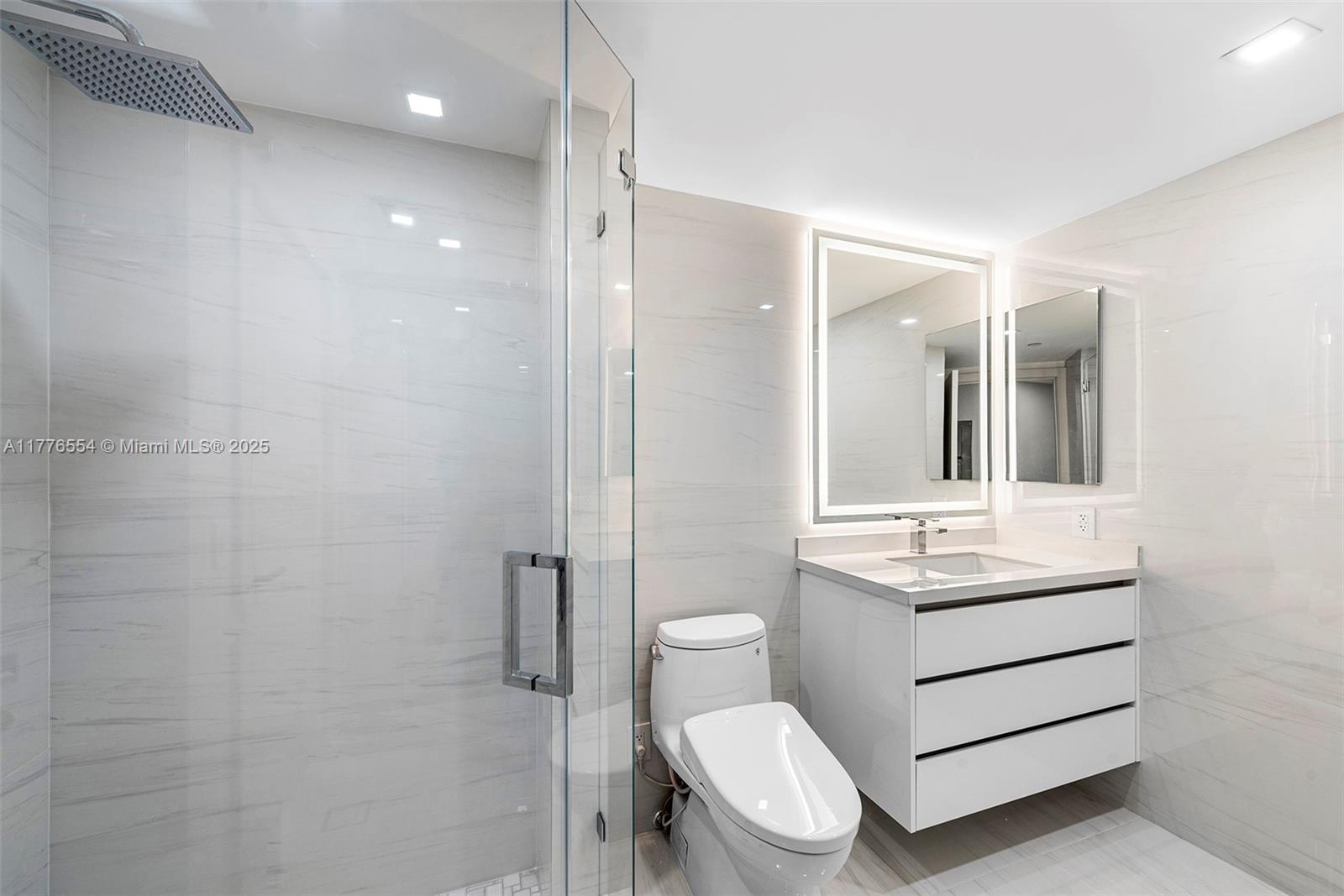 4775 Collins Avenue, Unit 2607 Miami Beach, FL 33140 - Photo 22 of 48 a bathroom with a sink a toilet a mirror and shower