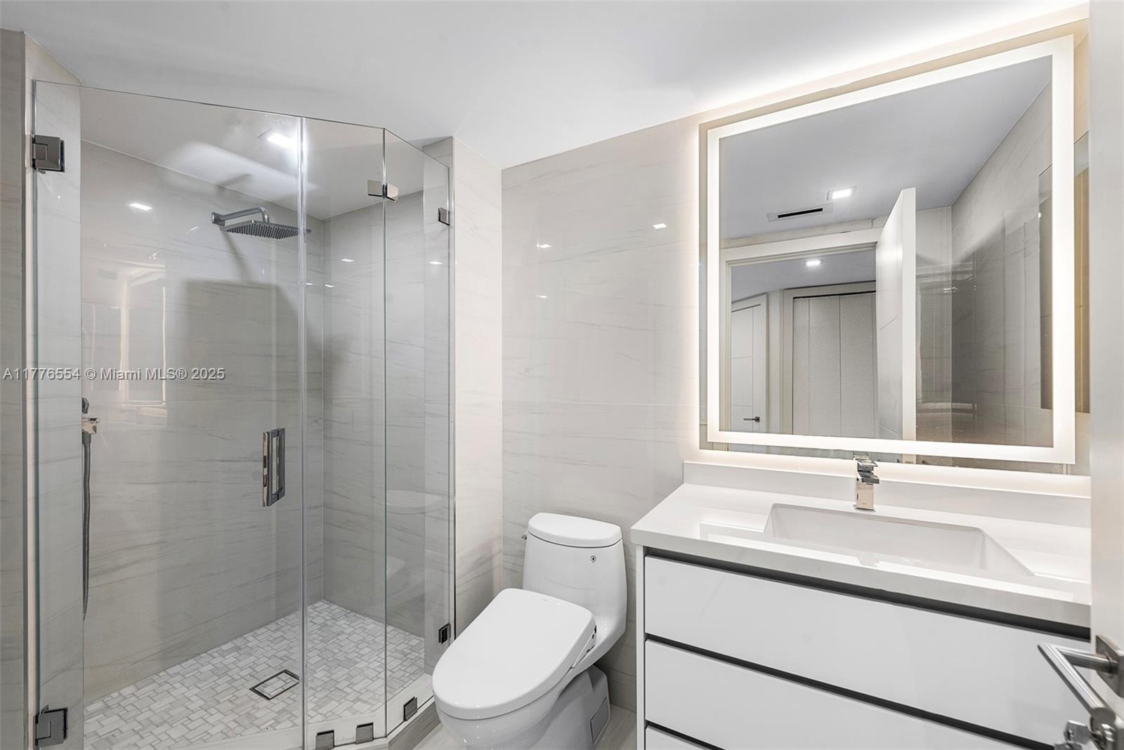 4775 Collins Avenue, Unit 2607 Miami Beach, FL 33140 - Photo 23 of 48 a bathroom with a sink toilet a mirror and shower