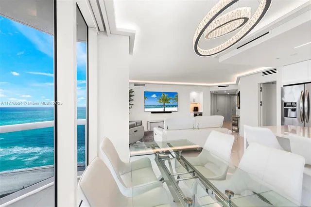 a living room with furniture a mirror and a floor to ceiling window