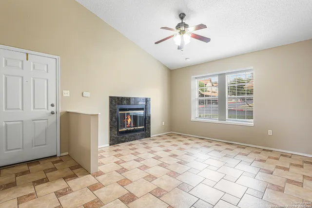 a view of an empty room with window and cabinet