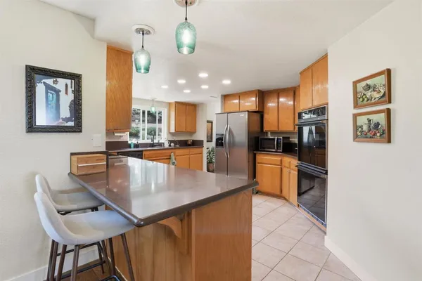a kitchen with stainless steel appliances granite countertop a refrigerator sink and stove