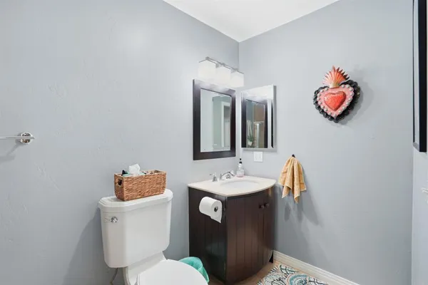 a bathroom with a granite countertop sink a toilet and a mirror