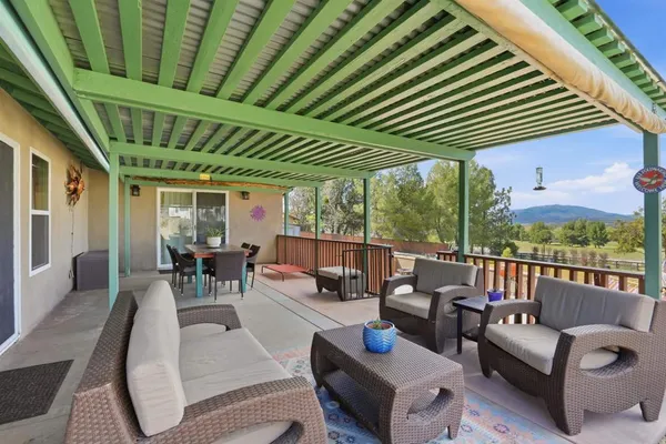 a view of a house with a yard and a large tree