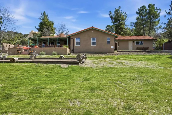 a backyard of a house with large trees and a yard