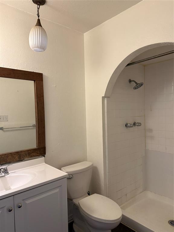 3801 Guthrie Road Garland, TX 75043 - Photo 16 of 24 Recessed shower area with arched entry, white tile surround, and chrome fixtures