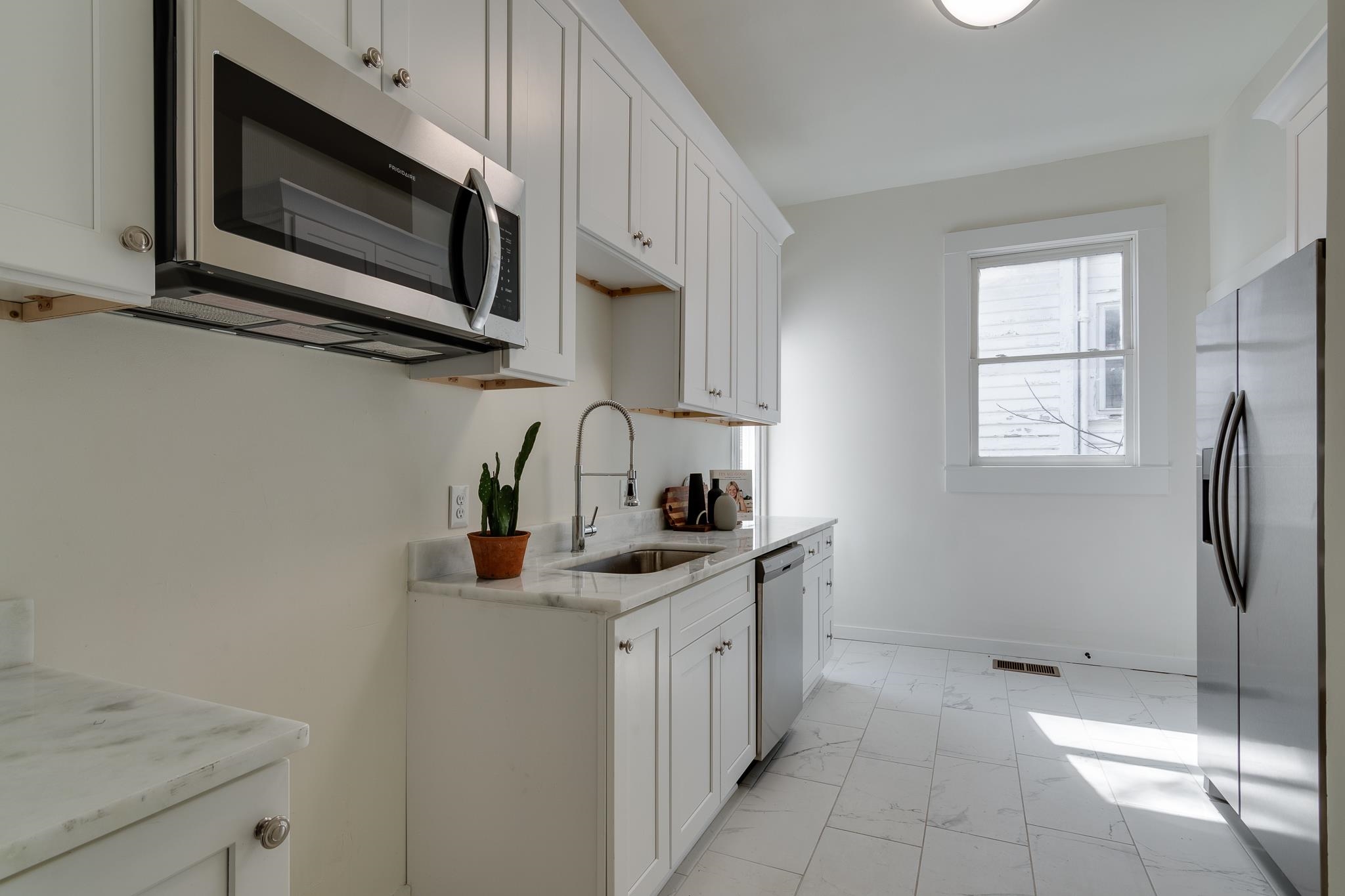 513 South Cox Street Memphis, TN 38104 - Photo 18 of 39 a kitchen with stainless steel appliances granite countertop a sink a stove a microwave and wooden cabinets