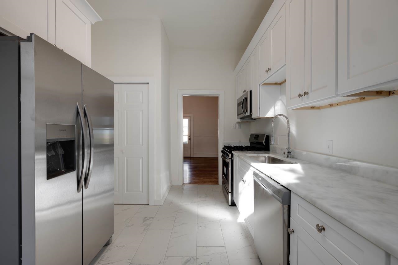 513 South Cox Street Memphis, TN 38104 - Photo 21 of 39 a kitchen with a refrigerator sink and cabinets