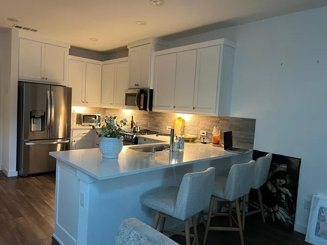 a kitchen with refrigerator dining table and chairs