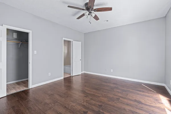 a view of an empty room with window and wooden floor