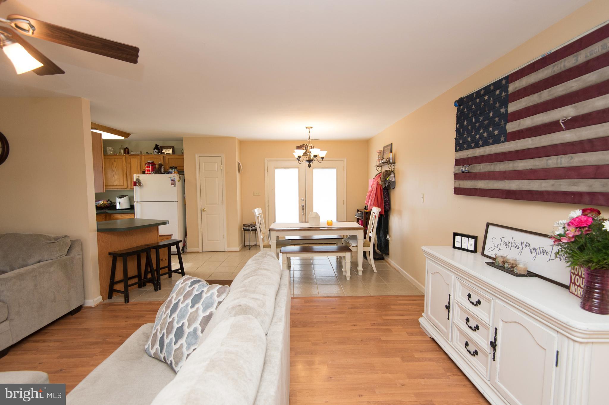 6568 Statum Road Preston, MD 21655 - Photo 7 of 49 a living room with furniture and a dining table with wooden floor