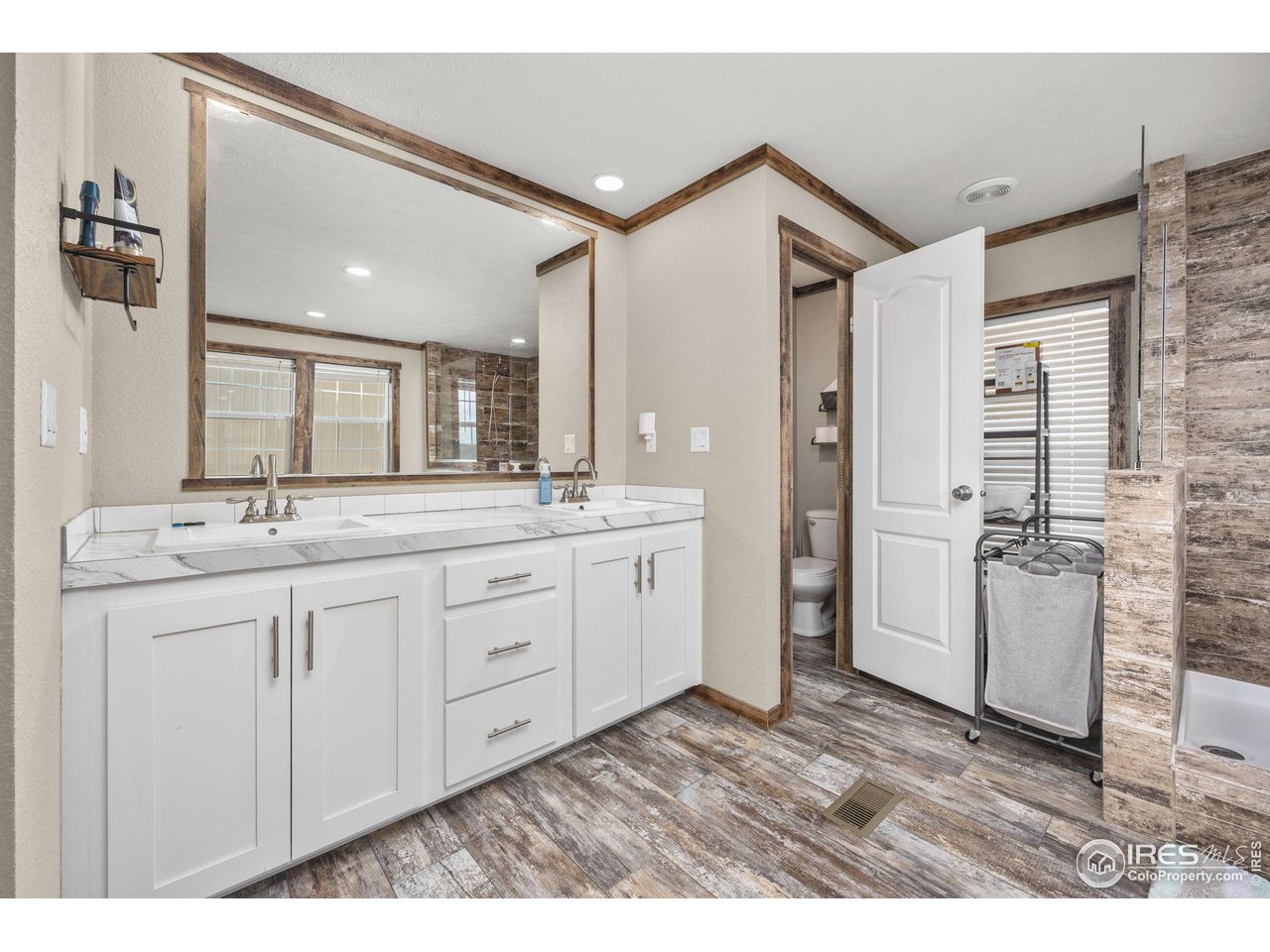 55102 County Road 21 Carr, CO 80612 - Photo 18 of 34 a spacious bathroom with a double vanity sink a mirror and a shower