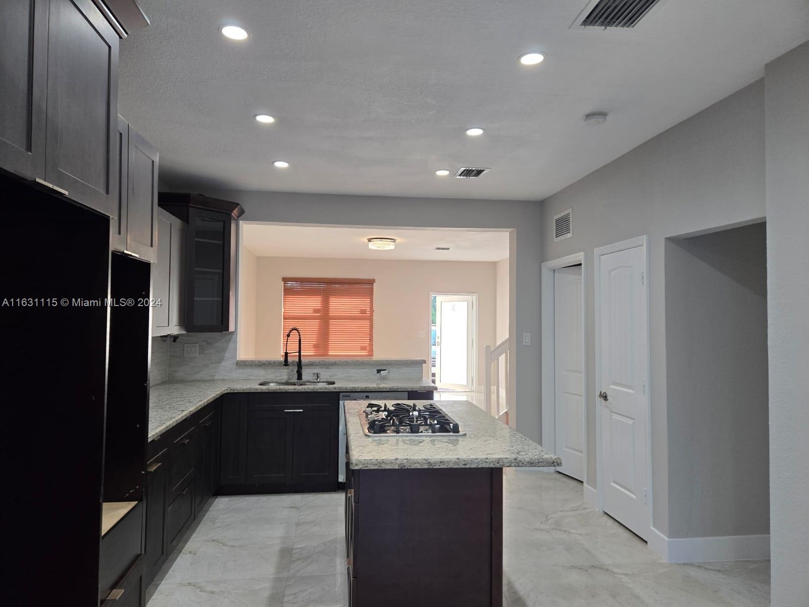 28407 Southwest 129th Place Homestead, FL 33033 - Photo 5 of 17 a kitchen with stainless steel appliances granite countertop a sink and a refrigerator