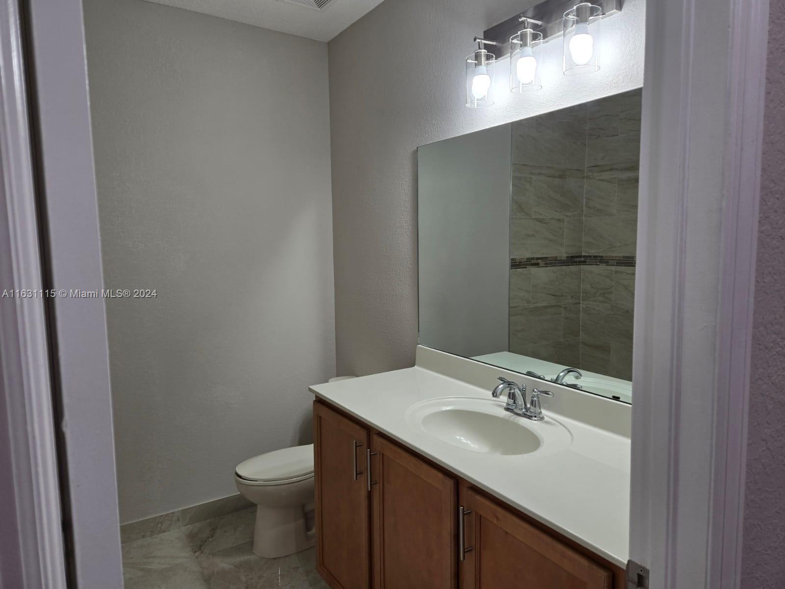 28407 Southwest 129th Place Homestead, FL 33033 - Photo 10 of 17 a bathroom with a sink toilet and mirror