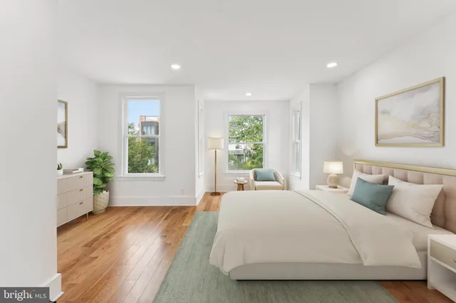 a bedroom with a large bed and a wooden floor