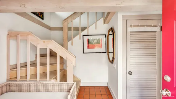 a view of staircase with railing and white walls