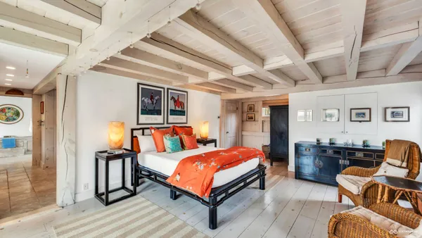 a bedroom with furniture and large windows