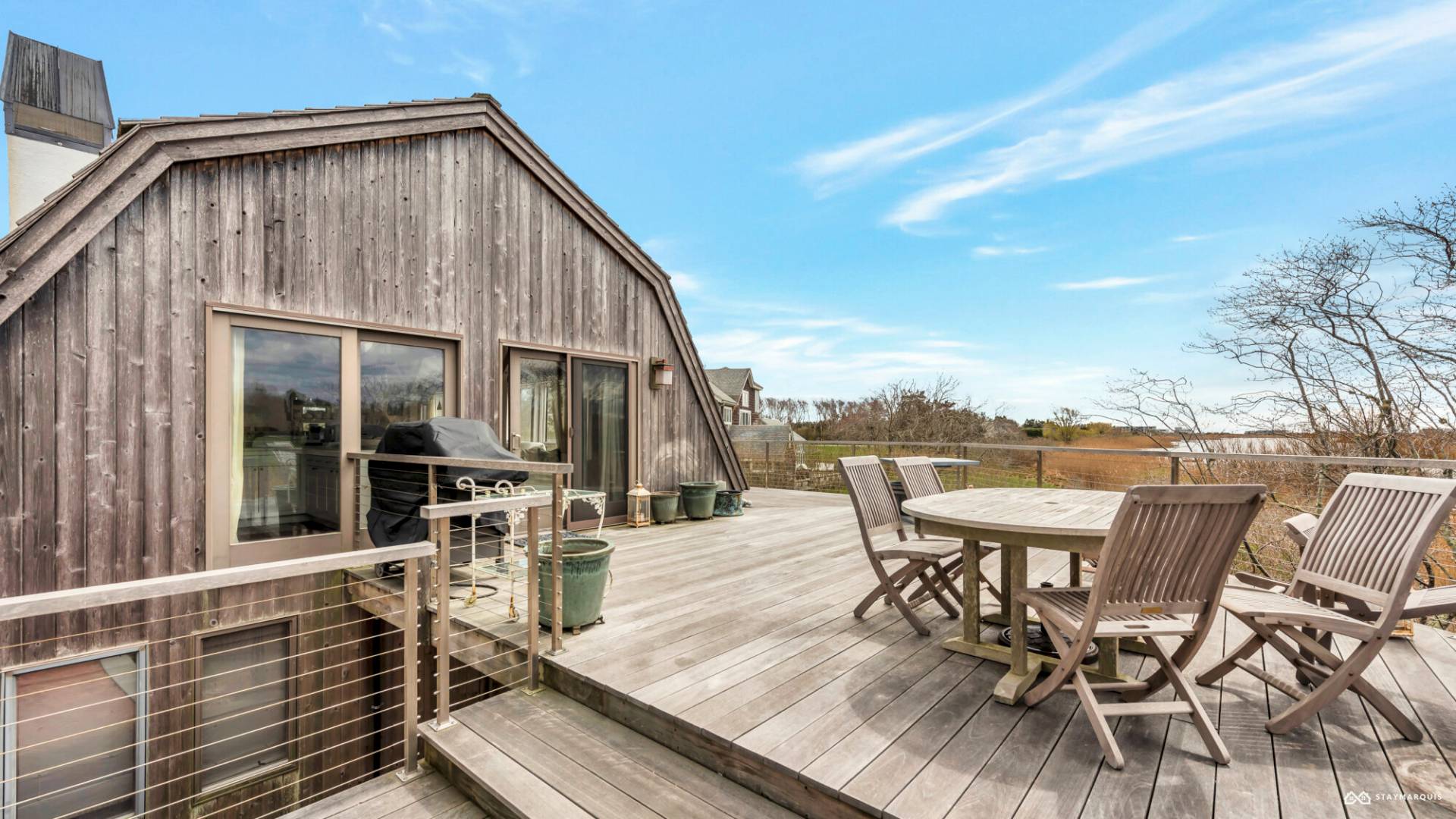 1100 Ocean Road Bridgehampton, NY 11932 - Photo 38 of 49 a roof deck with table and chairs and wooden floor