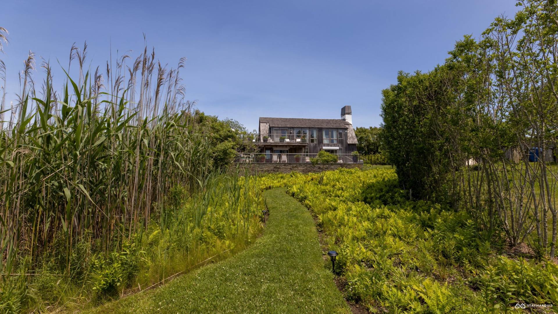 1100 Ocean Road Bridgehampton, NY 11932 - Photo 39 of 49 a view of a yard with plants and a brick wall