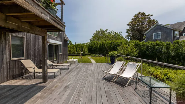 a balcony with wooden floor stairs and furniture
