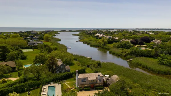 an aerial view of a house with a yard and lake view