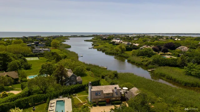 an aerial view of a house with a yard and lake view