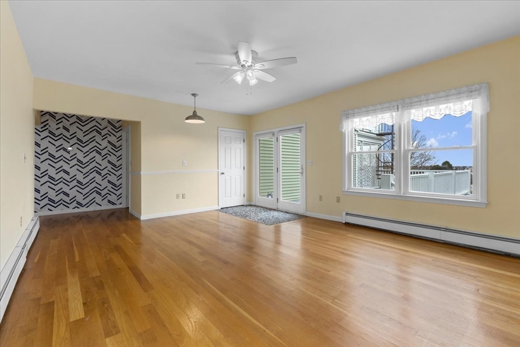 32 Barker Road, Unit 3 Scituate, MA 02066 - Photo 6 of 23 a view of an empty room with chandelier fan and wooden floor