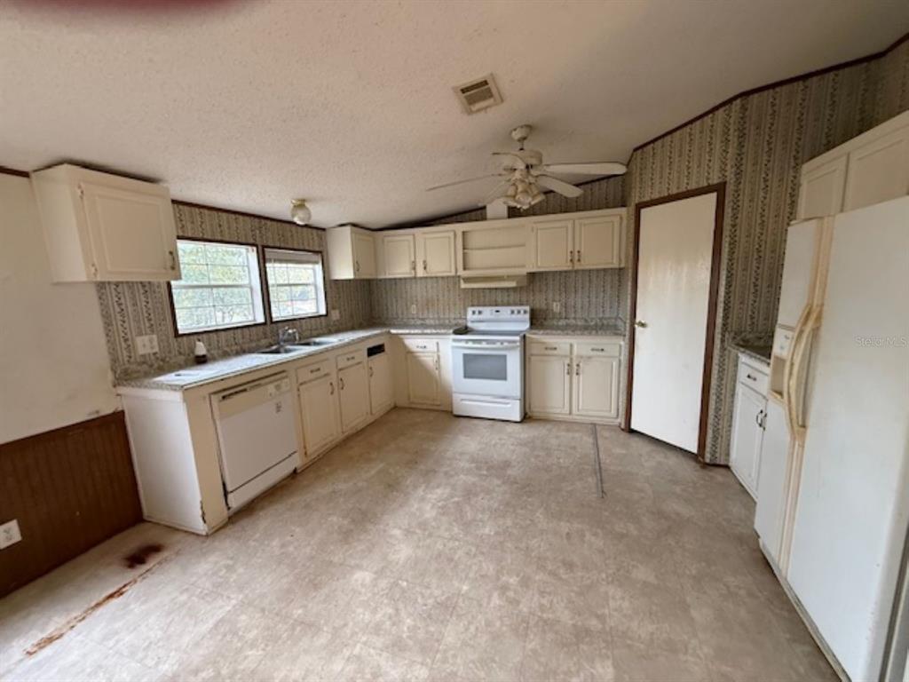 217 Longview Avenue Lady Lake, FL 32159 - Photo 3 of 10 a kitchen with a sink refrigerator and microwave