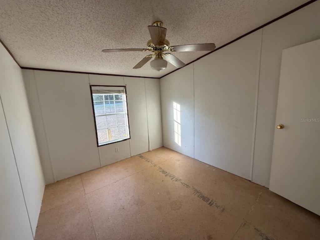 217 Longview Avenue Lady Lake, FL 32159 - Photo 7 of 10 an empty room with windows and fan