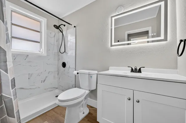 a bathroom with a sink toilet and shower
