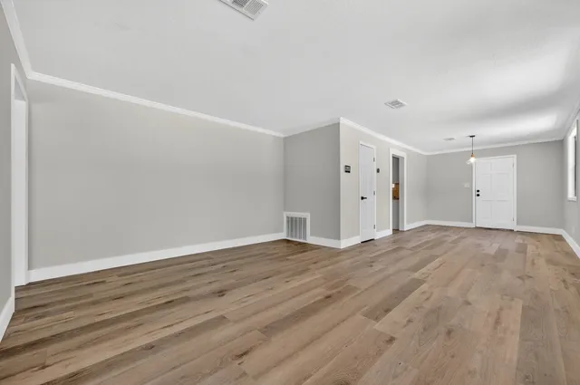 a view of empty room with wooden floor