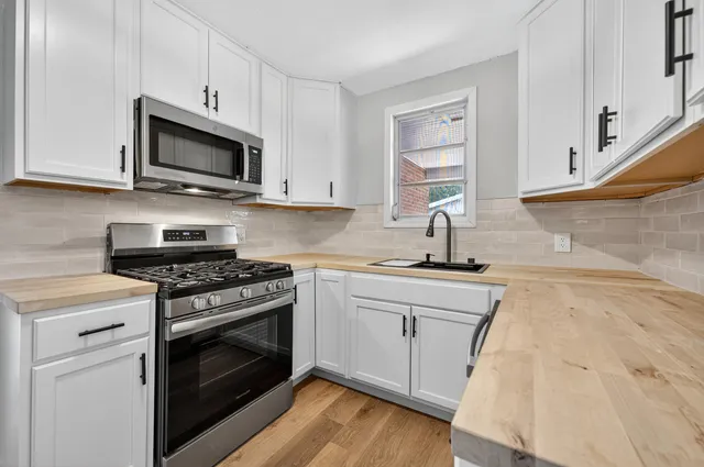a kitchen with stainless steel appliances a sink a stove and microwave