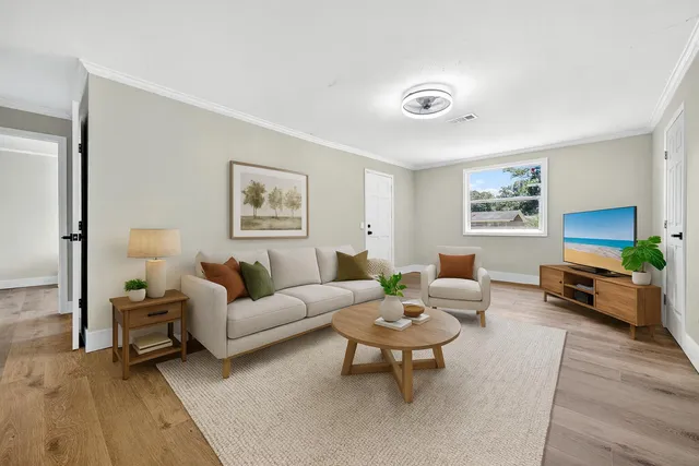 a living room with furniture and a wooden floor