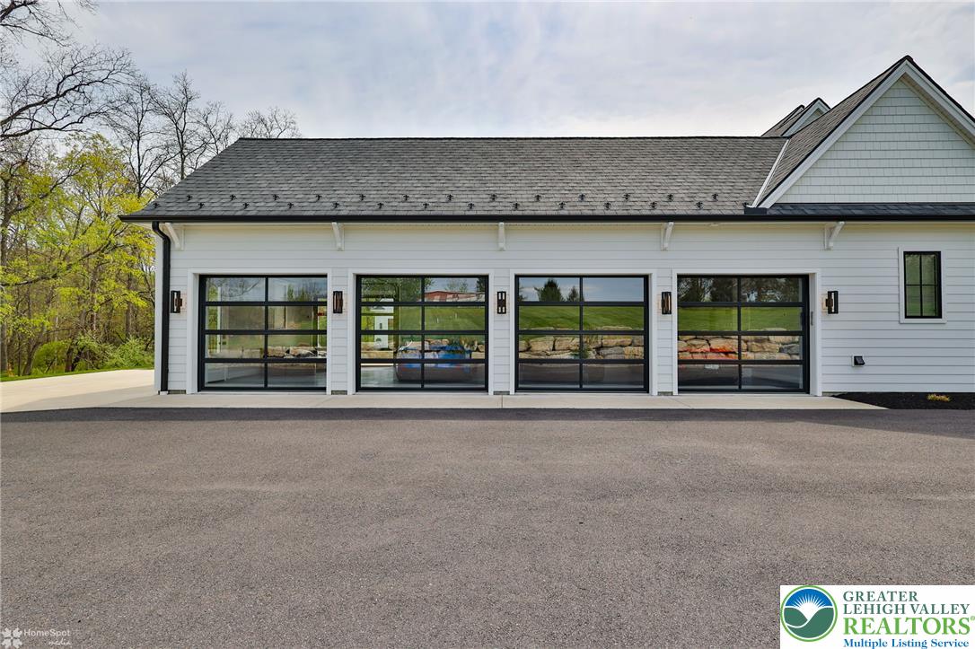 4850 West Hopewell Road Center Valley, PA 18034 - Photo 11 of 96 A striking contemporary garage with three glass-paneled doors elevates the home's architectural charm.