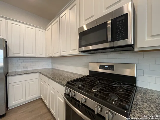a kitchen with granite countertop kitchen island a sink appliances and a counter space