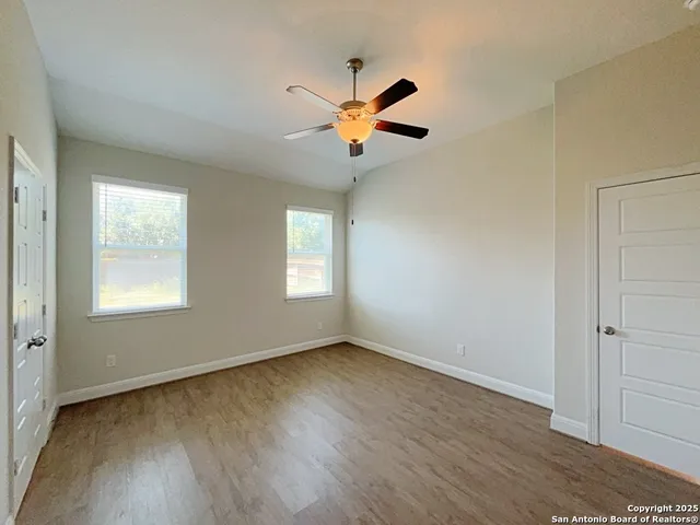 an empty room with closet and a chandelier fan