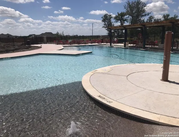 a view of a swimming pool with a yard and plants