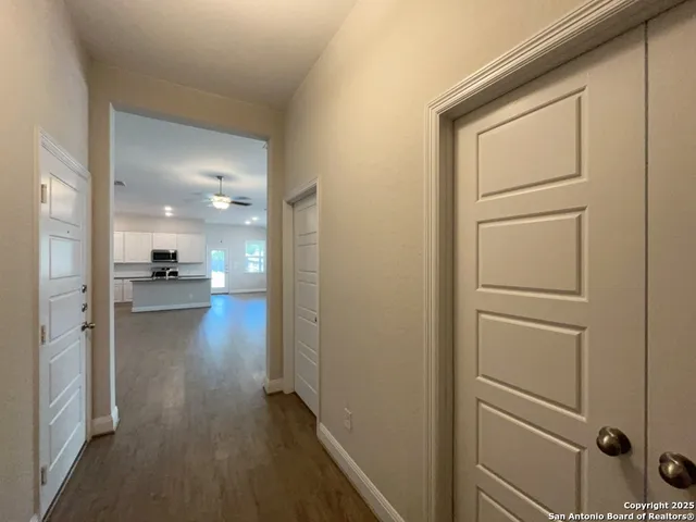a view of a hallway and closet with wooden floor
