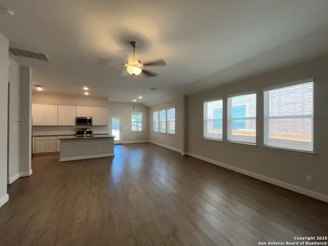 a view of a living room a kitchen and a wooden floor