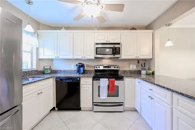 a kitchen with kitchen island granite countertop a sink counter top space appliances and cabinets