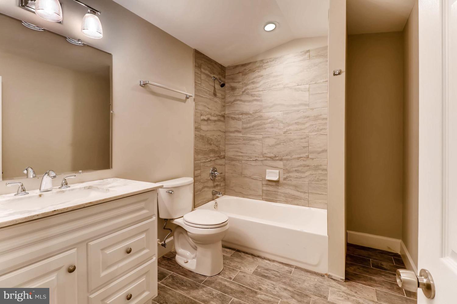 8103 Bullneck Road Baltimore, MD 21222 - Photo 20 of 26 a bathroom with a granite countertop sink a toilet and bathtub