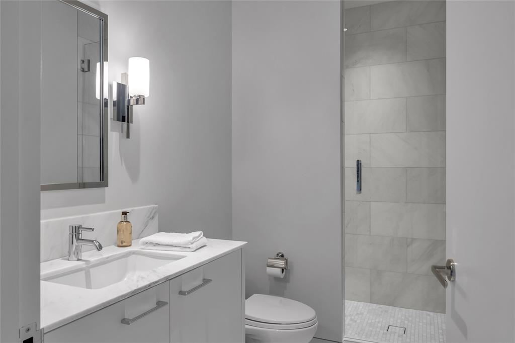 1747 Leonard Street, Unit 1402 Dallas, TX 75201 - Photo 21 of 36 a bathroom with a sink toilet vanity and shower