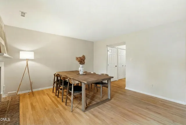 a view of a room with wooden floor table and chairs