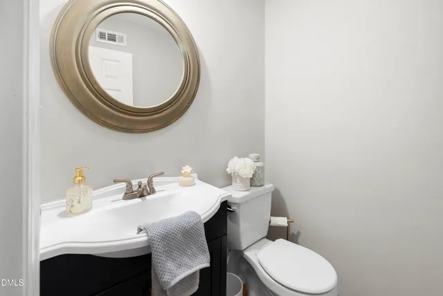 a bathroom with a sink mirror and toilet