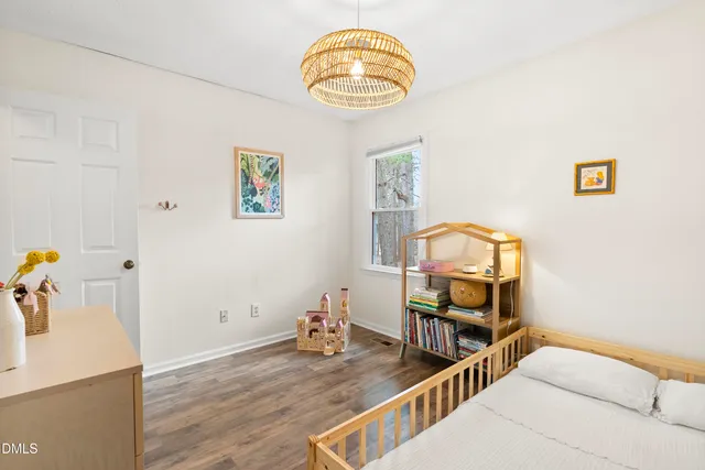 a view of a bedroom with furniture and wooden floor
