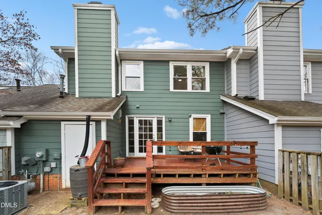 a view of a house with wooden deck and furniture
