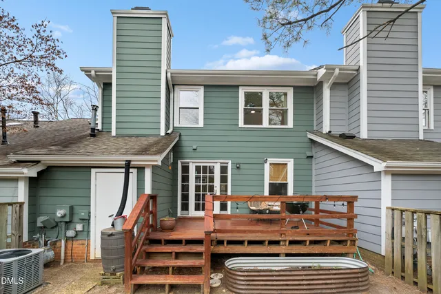 a view of a house with wooden deck and furniture
