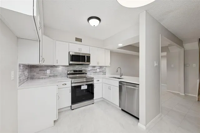 a kitchen with a sink stove and microwave